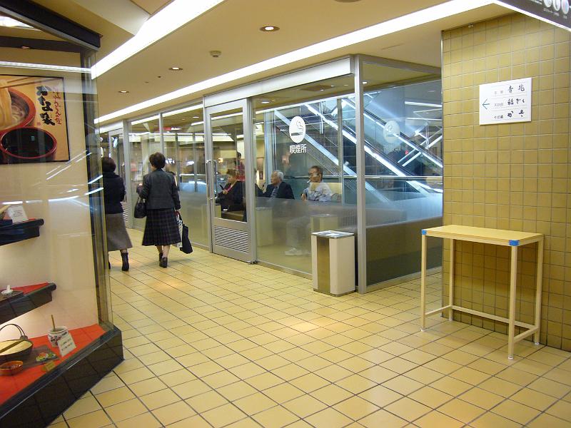 foto_20081110_1328_01.jpg - [de]So gefällt uns das - Raucher werden eingesperrt.[en]Smokers are put inside a glass box in the department store.